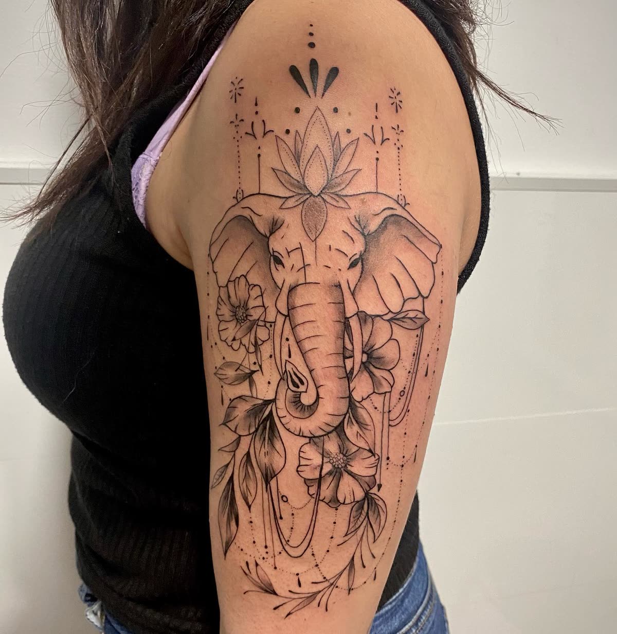 Hombro en línea fina: elefante con flor de loto, flores y cadenas de puntos